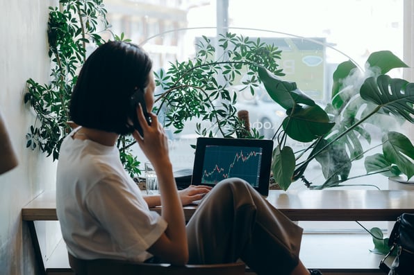 Businesswoman on her phone around plants, finding out more about the Pension Funds getting involved with the Net Zero Carbon Emissions commitment.